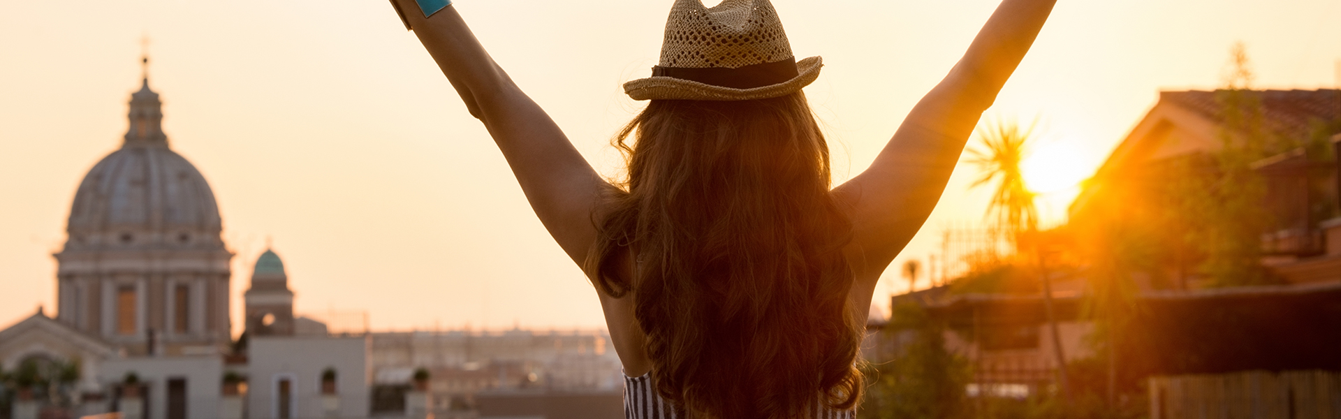 Femme avec les bras en l'air à Rome avec un coucher de soleil en arrière-plan